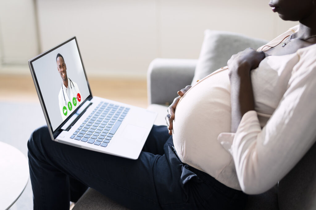 Pregnant woman in telehealth visit on laptop