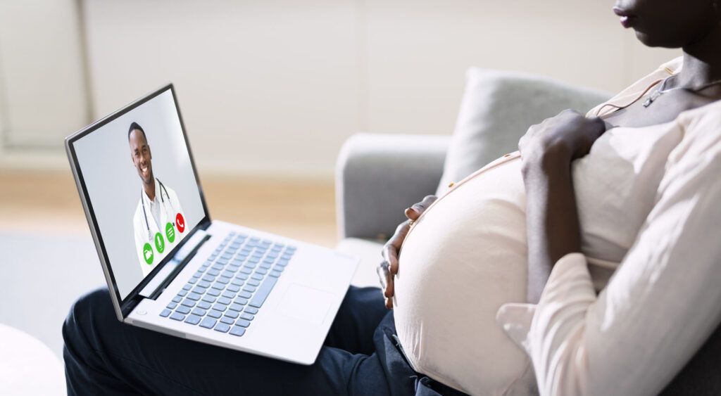 Pregnant woman in telehealth session on a laptop