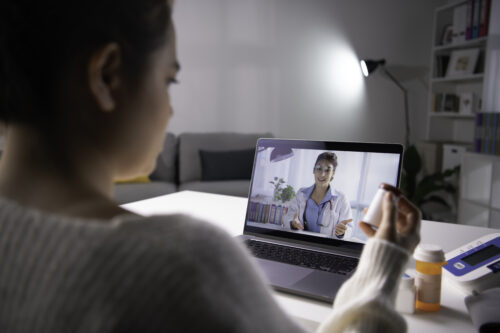 Patient consults with physician in telehealth visit on laptop computer