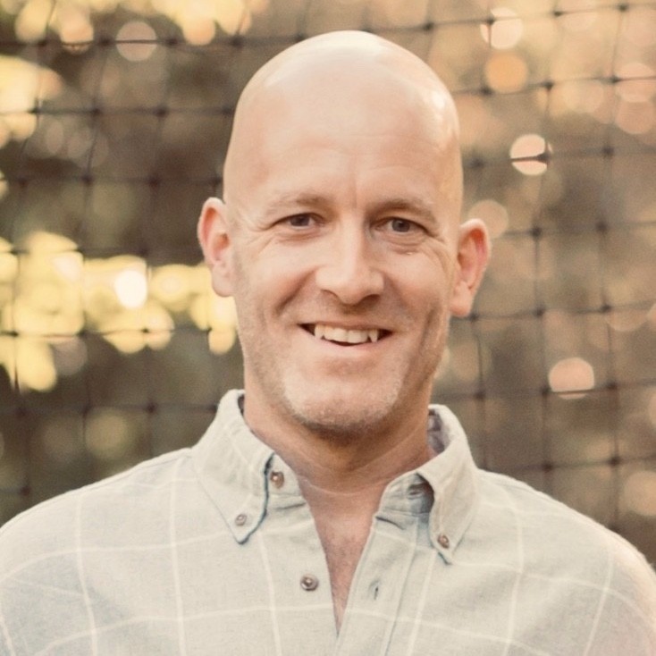 Dave Idle smiling in a casual outdoor setting